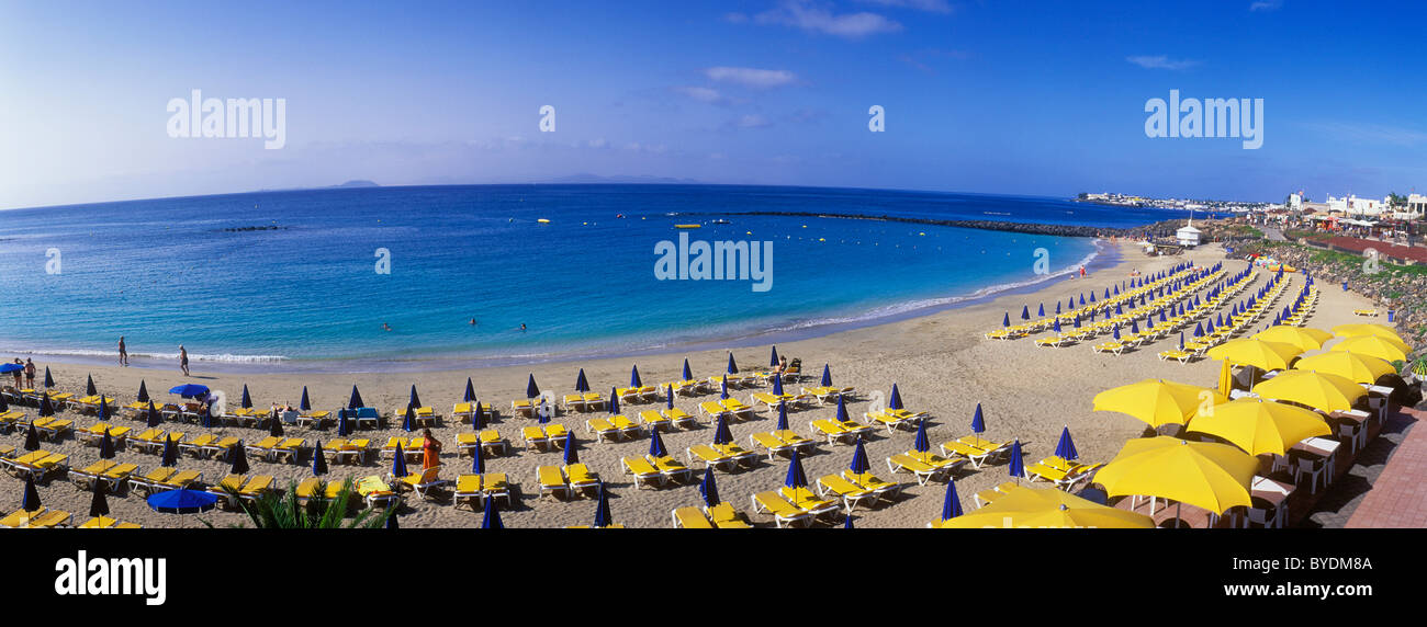 Il giallo sole ombrelloni su di una spiaggia di sabbia, Playa Dorada, Playa Blanca, Lanzarote, Isole Canarie, Spagna, Europa Foto Stock