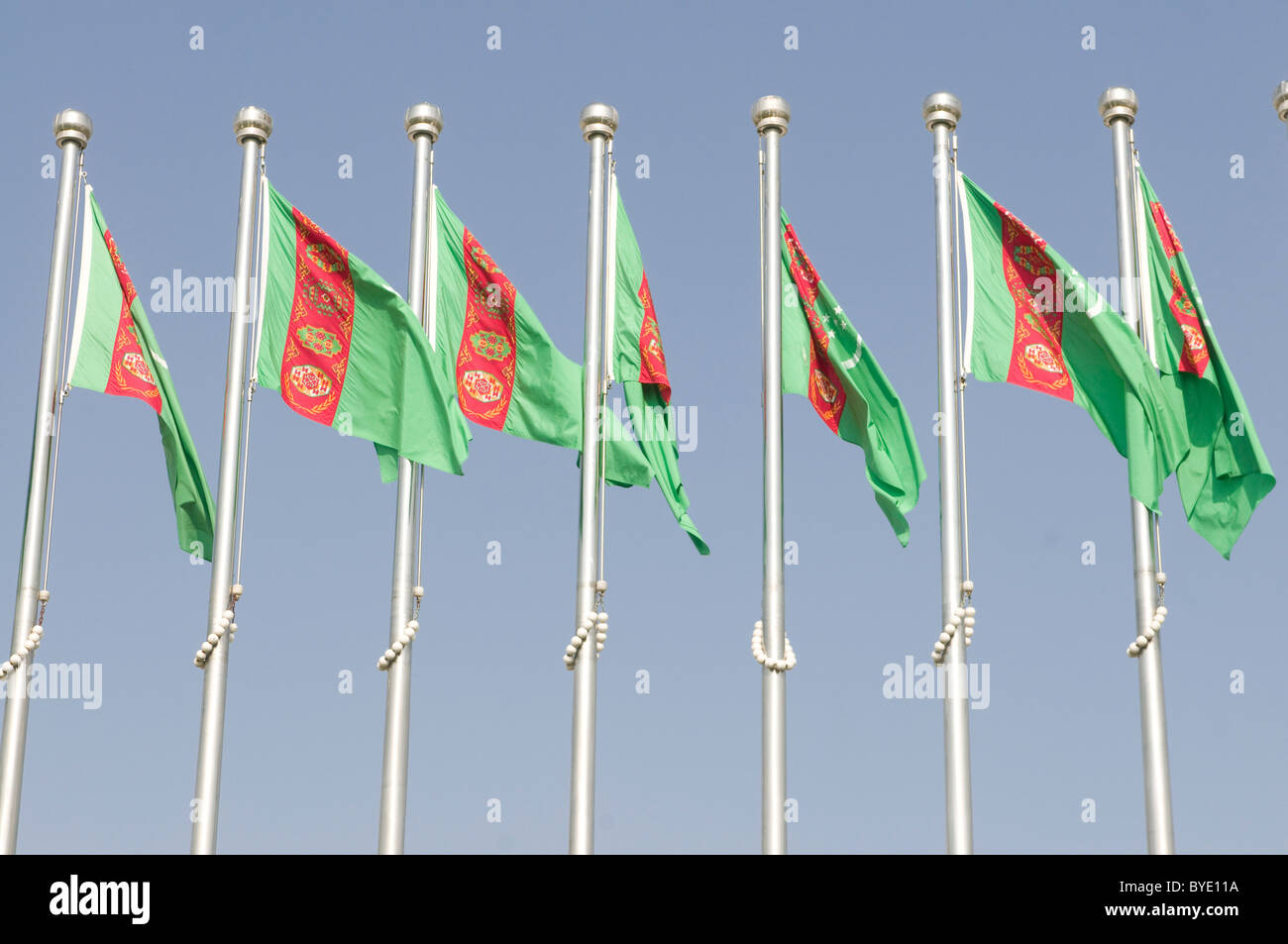 Il turkmeno bandiere nazionali al vento, Aşgabat, del Turkmenistan, dell'Asia centrale Foto Stock