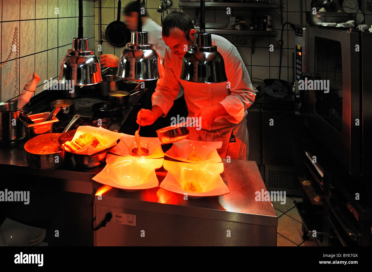 Lo chef prepara un menu in un ristorante di cucina, piastre essendo  riscaldata sotto lampade riscaldanti, Auberge de la Ferme Hueb,  Marckolsheim Foto stock - Alamy