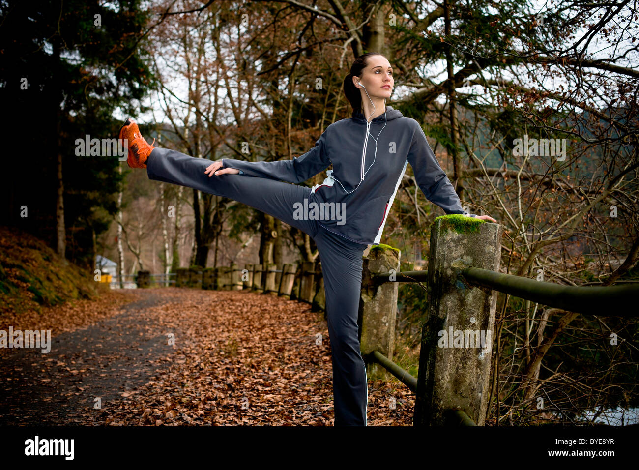 Giovane donna facendo il riscaldamento esercizi prima di jogging Foto Stock