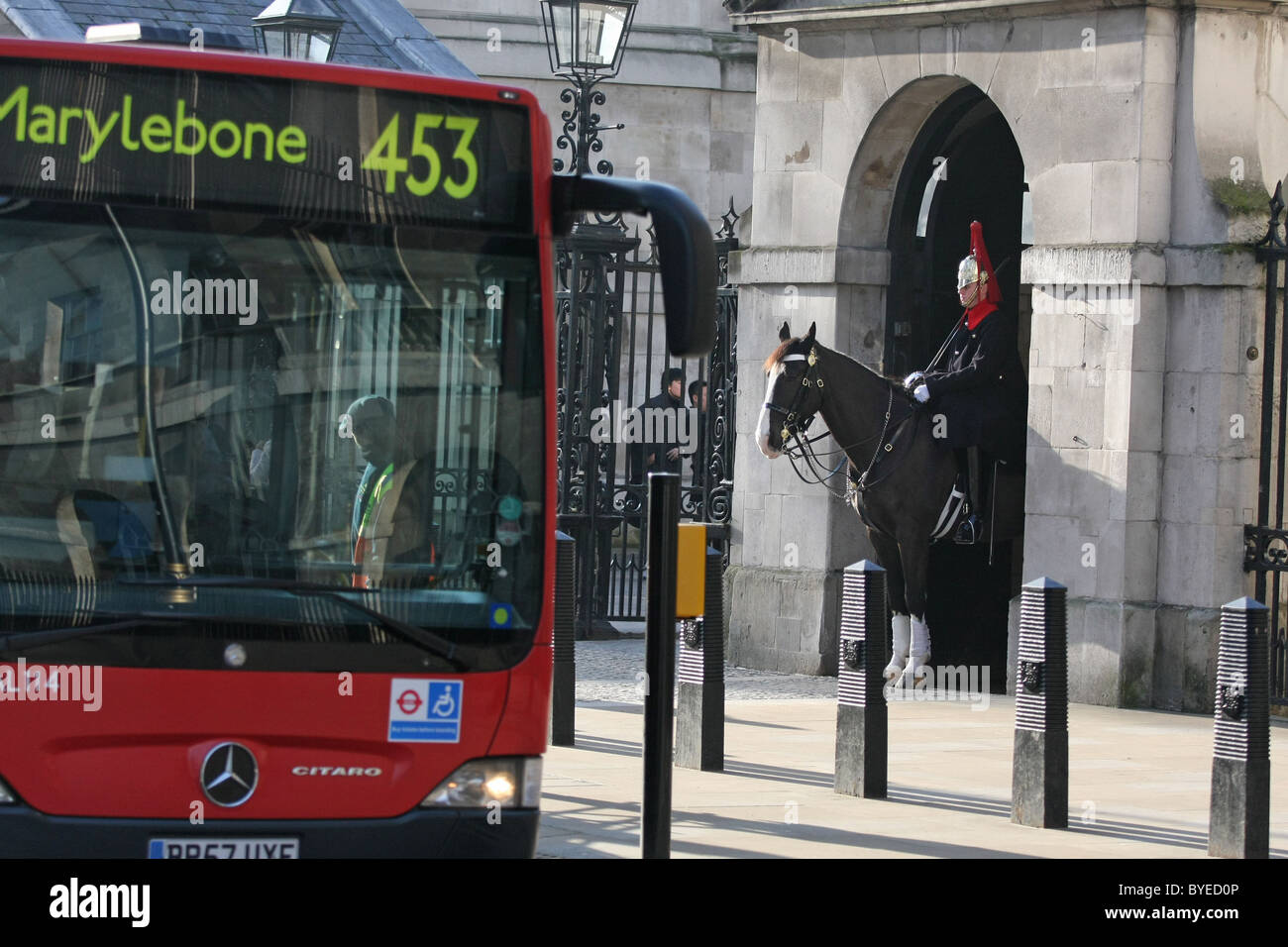 Uno di Regina della vita delle guardie sul dovere con un bus londinese passando Foto Stock