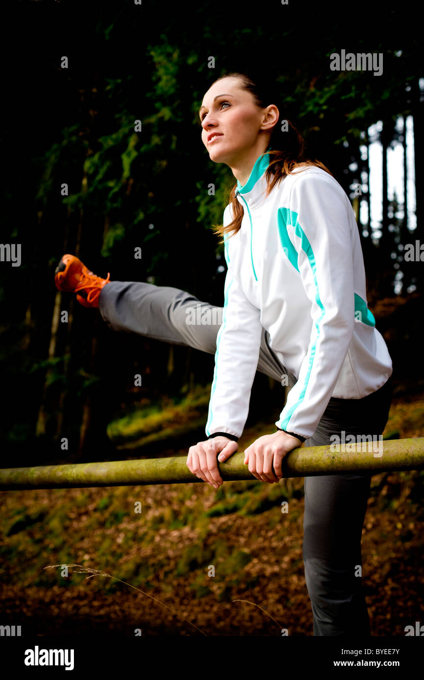 Giovane donna facendo il warm-up di esercizi per il jogging Foto Stock