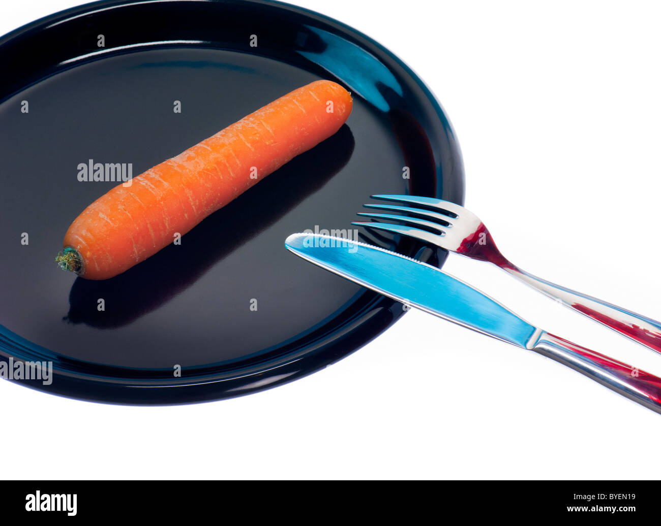 Simbolo mangiare meno carota dieta a basso contenuto di grassi senza obesità slim piastra nera veggi verdure coltello forcella tablett decrescente simbolico Foto Stock
