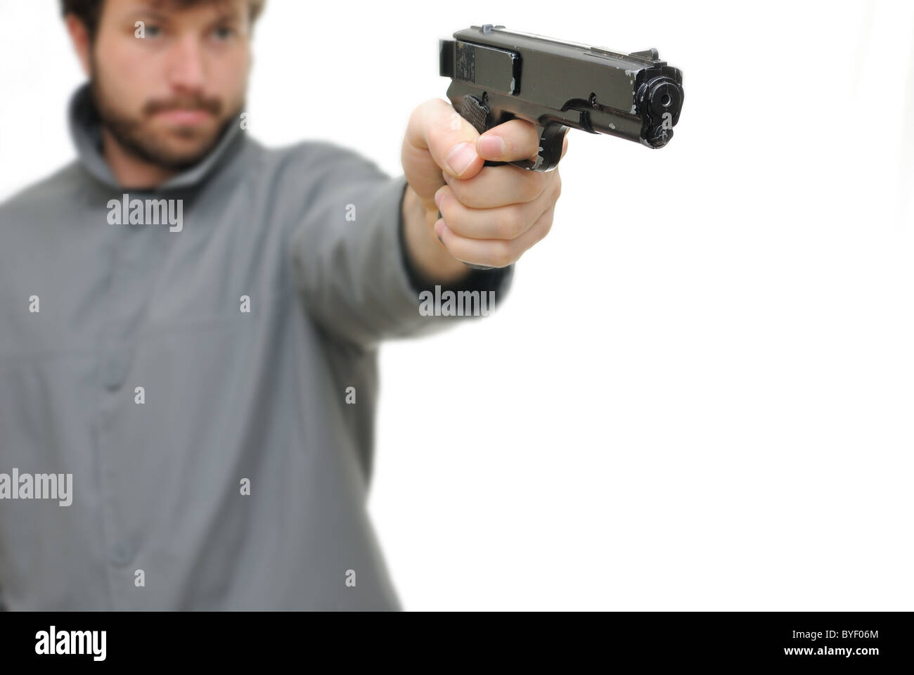 Un uomo indica una pistola isolati su sfondo bianco. Foto Stock