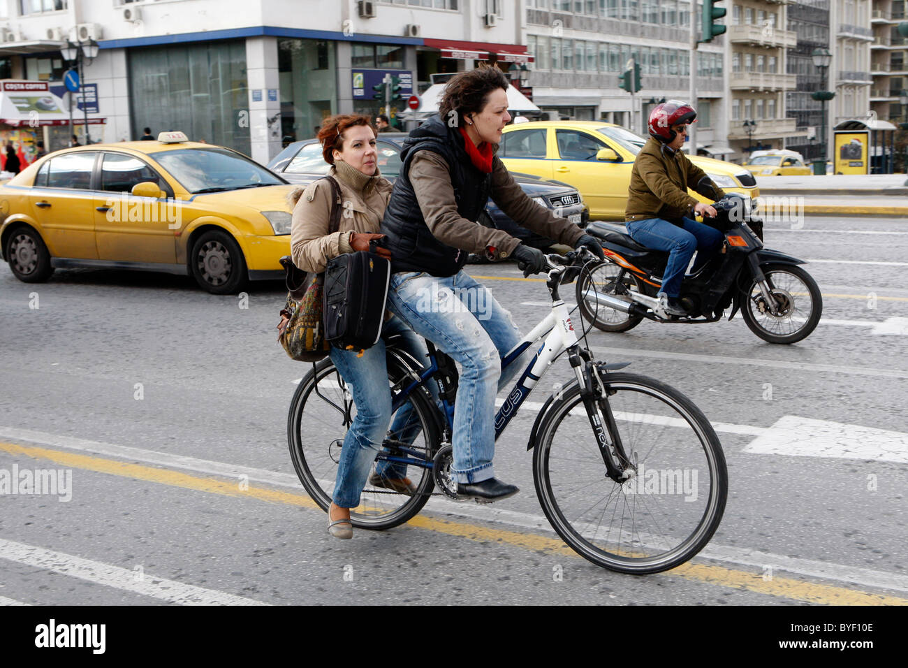 Cicli di donne tra i veicoli in coda in un ingorgo durante 48 ore di sciopero dei trasporti pubblici in Atene. Foto Stock