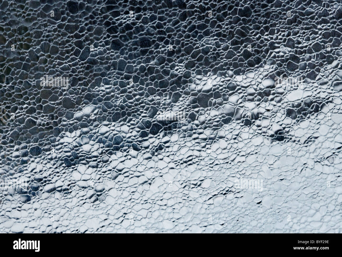 Un sottile strato di ghiaccio su un auto parabrezza parabrezza ot Foto Stock