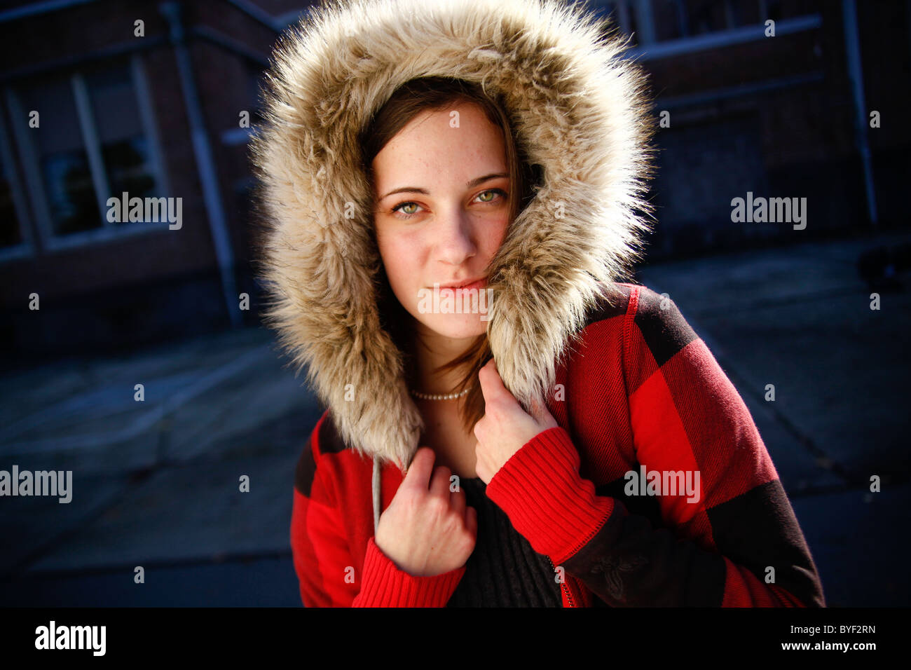 Piuttosto giovane donna in rosso plaid felpa con cappuccio di pelliccia  cappotto guardando la fotocamera Foto stock - Alamy