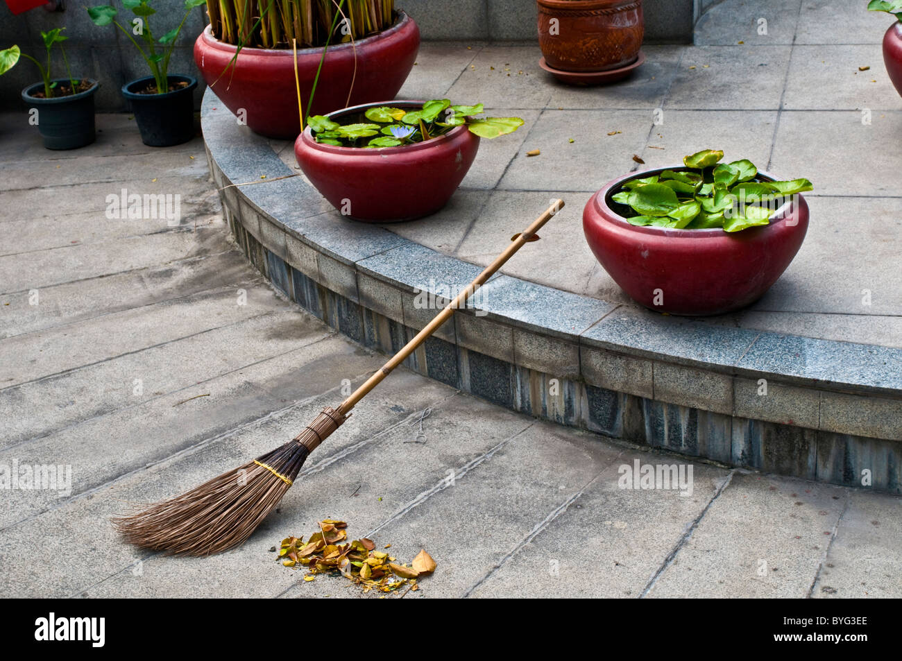 Scopa e foglie morte, 14 ottobre Memorial, Bangkok, Thailandia Foto Stock