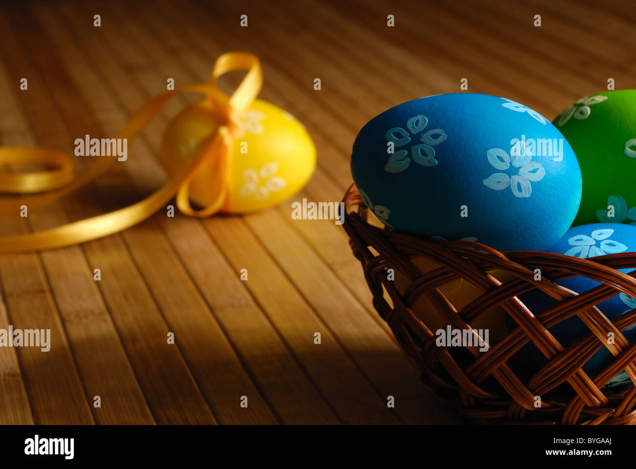 Uova di Pasqua nel cesto di vimini sul tavolo di legno scuro foto Foto Stock