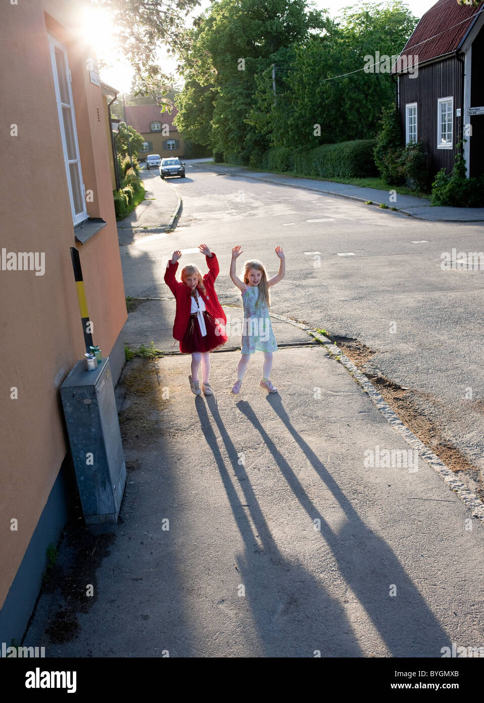 Le ragazze in piedi sul marciapiede e alzando le mani Foto Stock