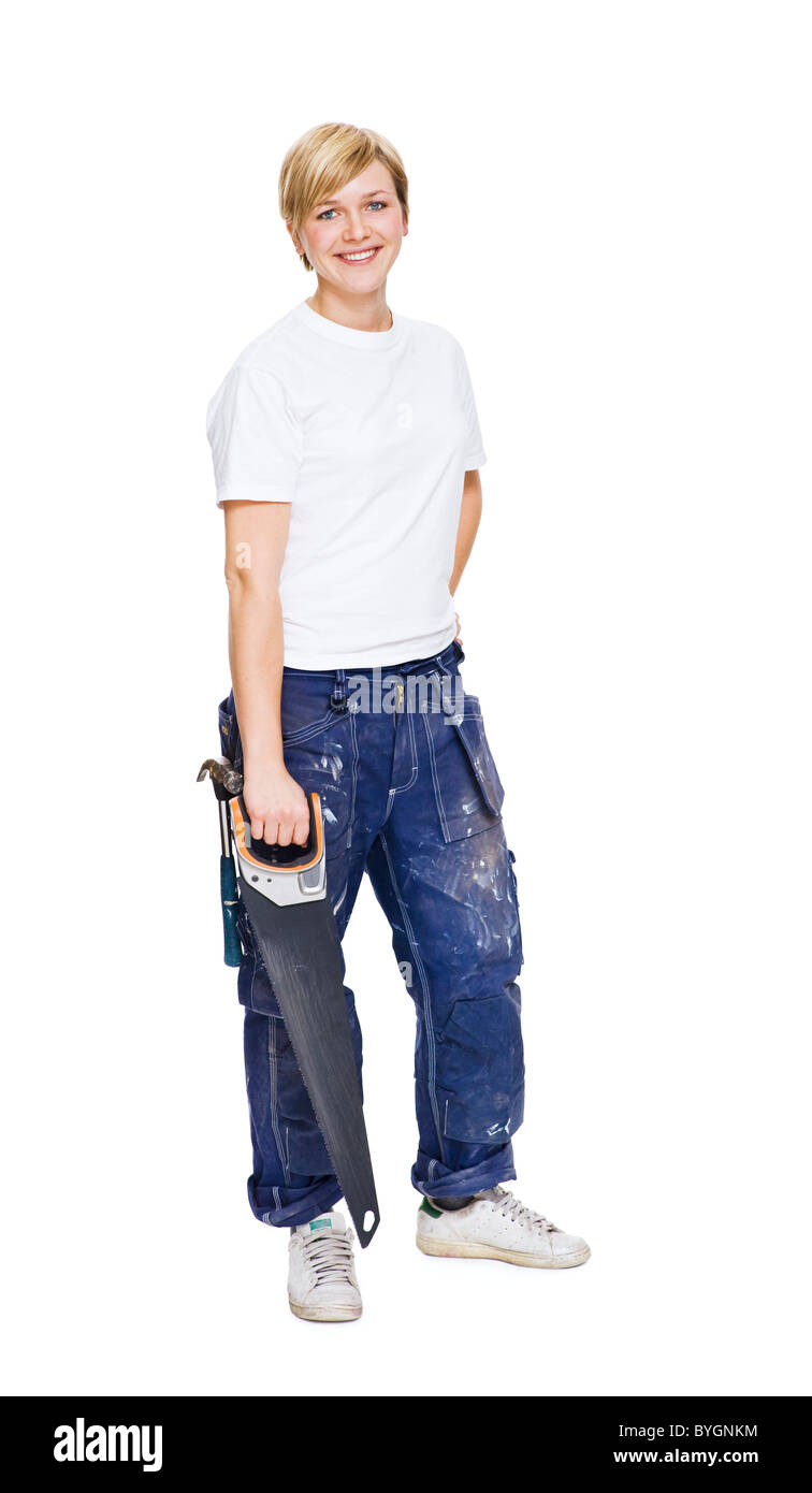 Donna che mantiene visto in piedi contro uno sfondo bianco, sorridente, ritratto Foto Stock