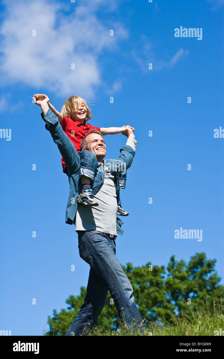 Padre piggy backing la figlia a non paesaggio urbano Foto Stock