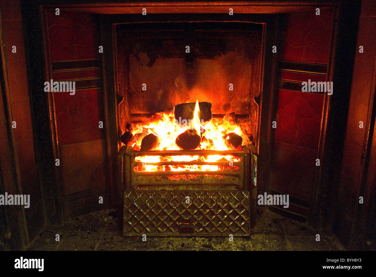 Uno scoppiettante fuoco di carbone in un tradizionale caminetto Foto Stock