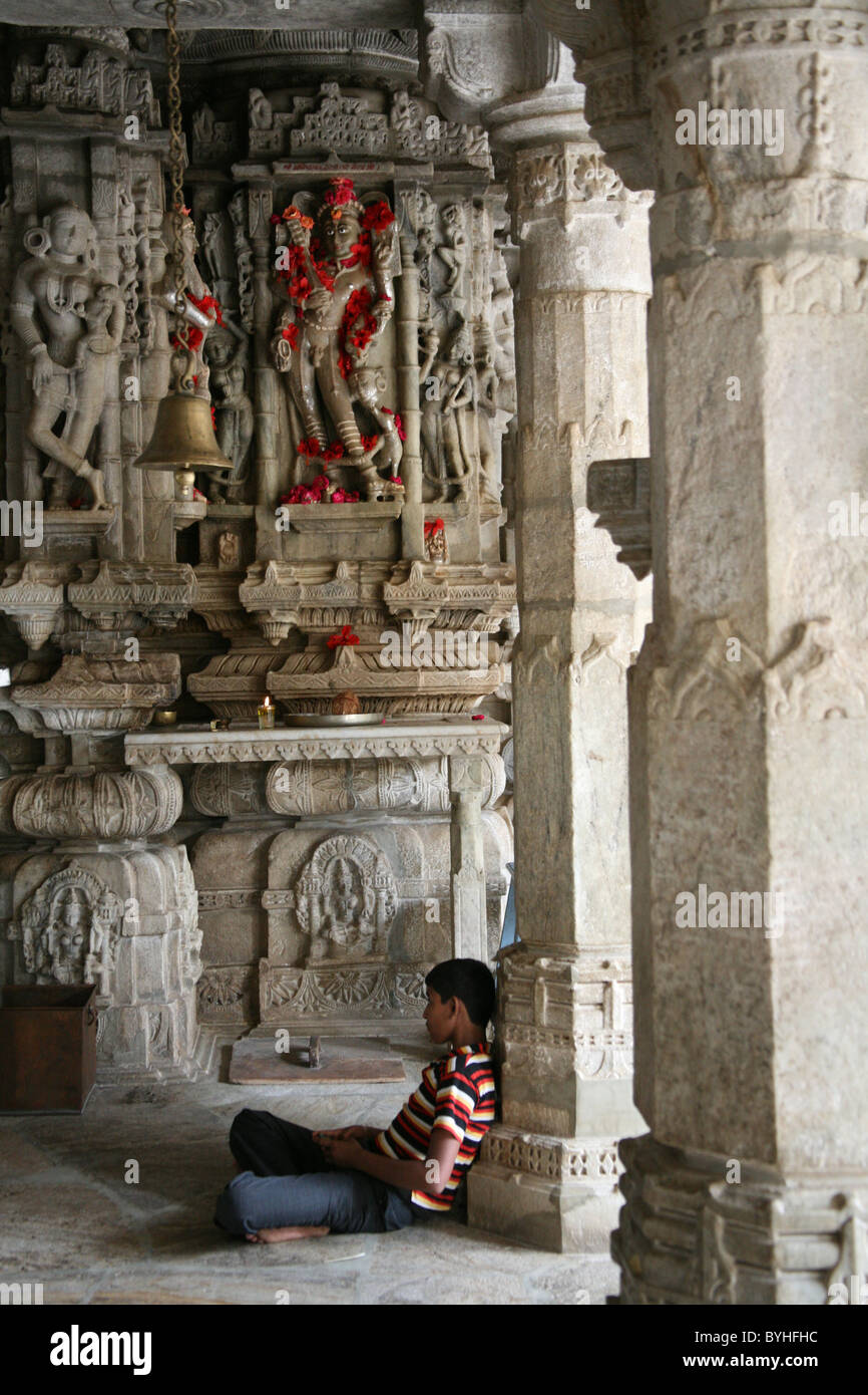 Seduto solitario adoratore al marmo Adishwar Giainista Chaumukha Mandir Tempio Ranakpur Rajasthan Foto Stock