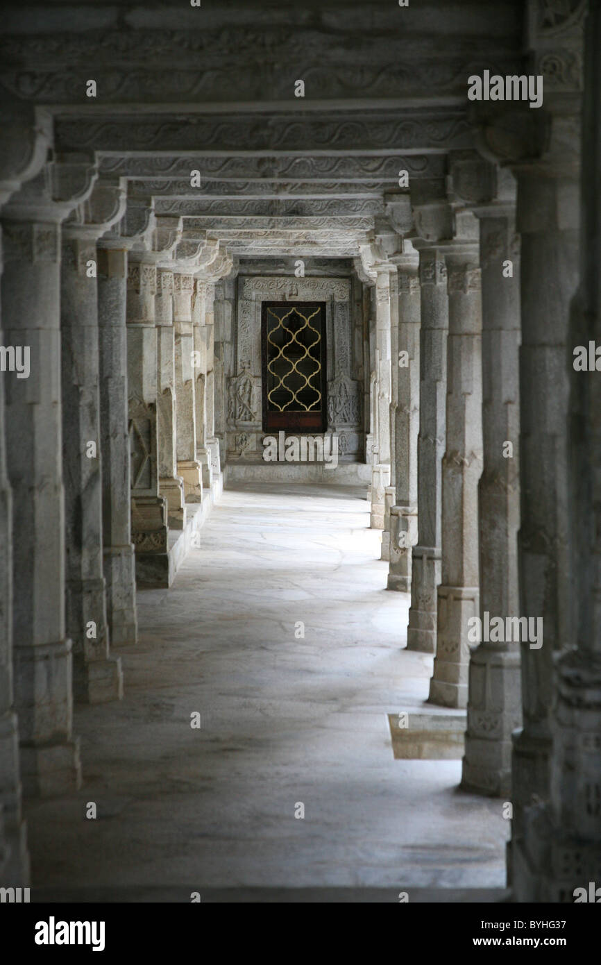 Colonne scolpite che conduce ad un santuario al marmo Adishwar Giainista Chaumukha Mandir Tempio Ranakpur, Rajasthan Foto Stock