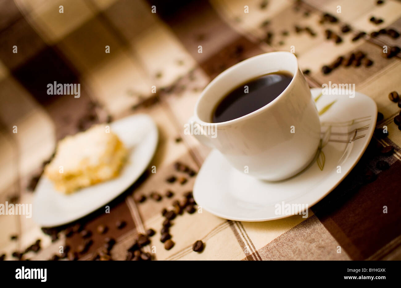 Tazza di caffè e una fetta di torta sul tavolo, torta a sfondo sfocato Foto Stock