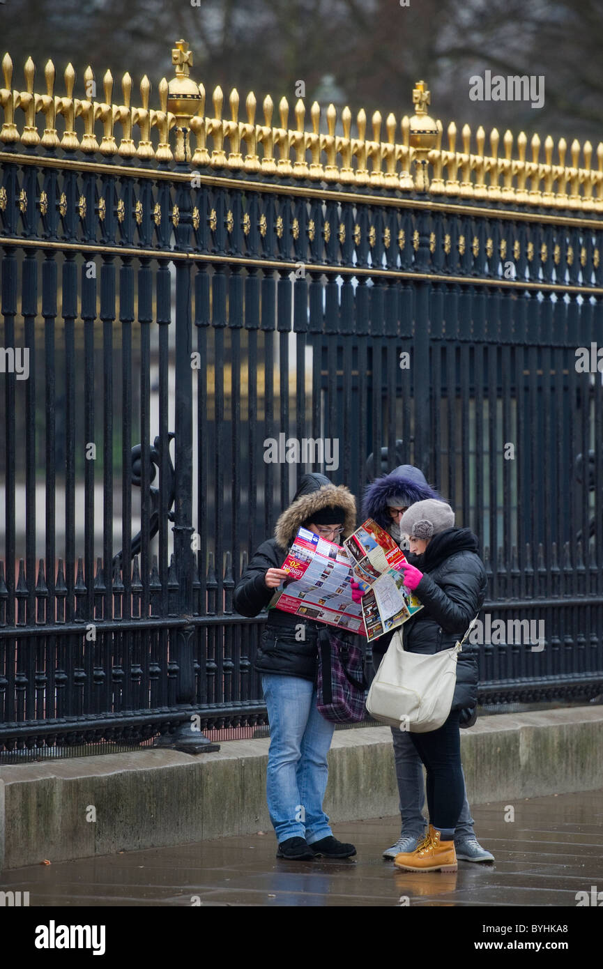 I turisti controllare una mappa fuori Buckingham Palace Foto Stock