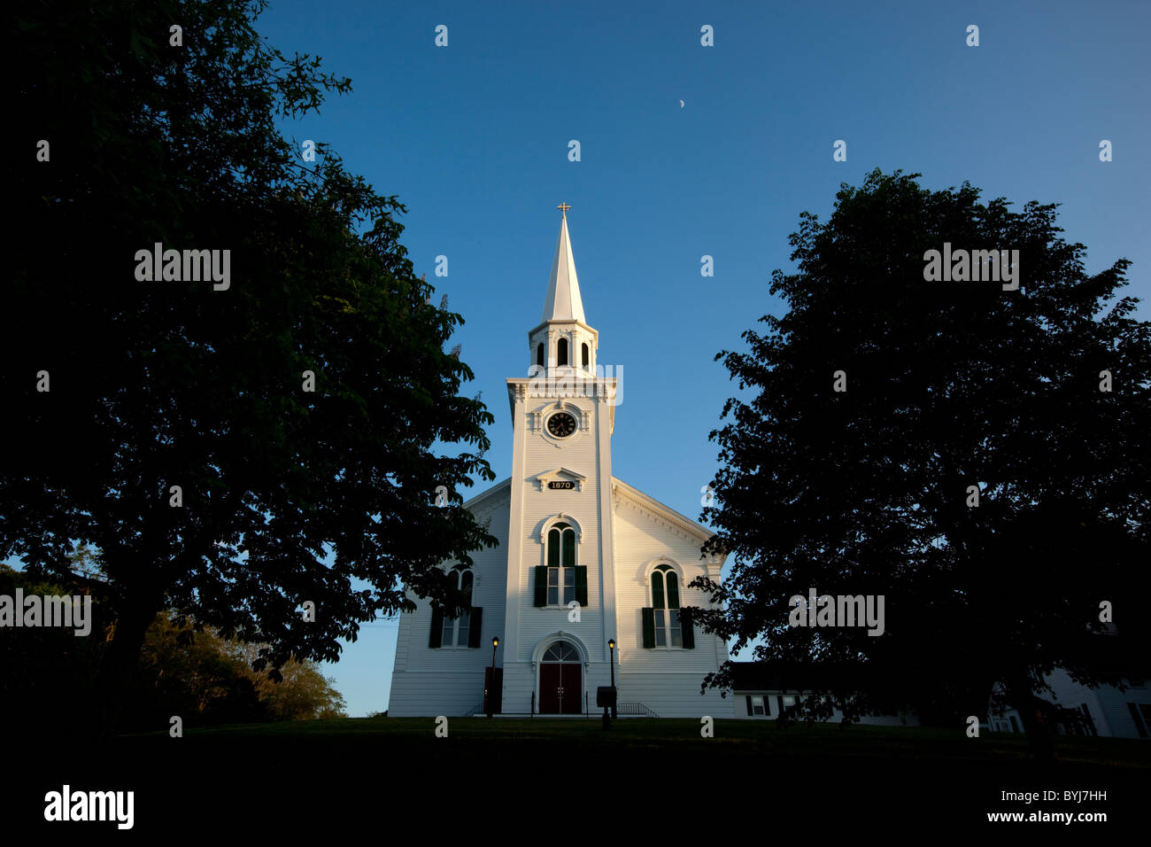 Stati Uniti d'America, Massachusetts, Yarmouth Port, impostando il sole illumina il campanile bianco della prima chiesa congregazionale sulla serata estiva Foto Stock