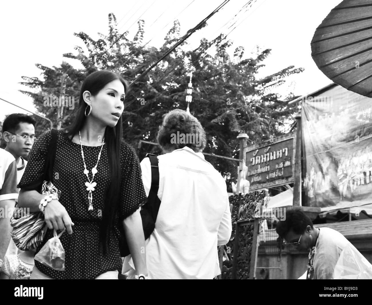 Fotografia in bianco e nero di una donna Thai a piedi lungo una strada del mercato di Chiang Mai Foto Stock