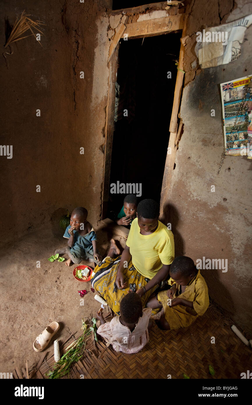 Una famiglia condivide un pasto insieme nella loro casa di fango in Masaka, Uganda, Africa orientale. Foto Stock