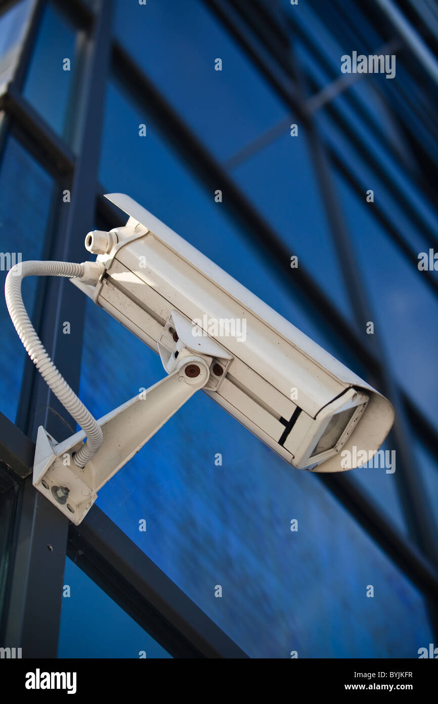 Videocamera di sicurezza fissato su edificio aziendale con riflessioni Foto Stock