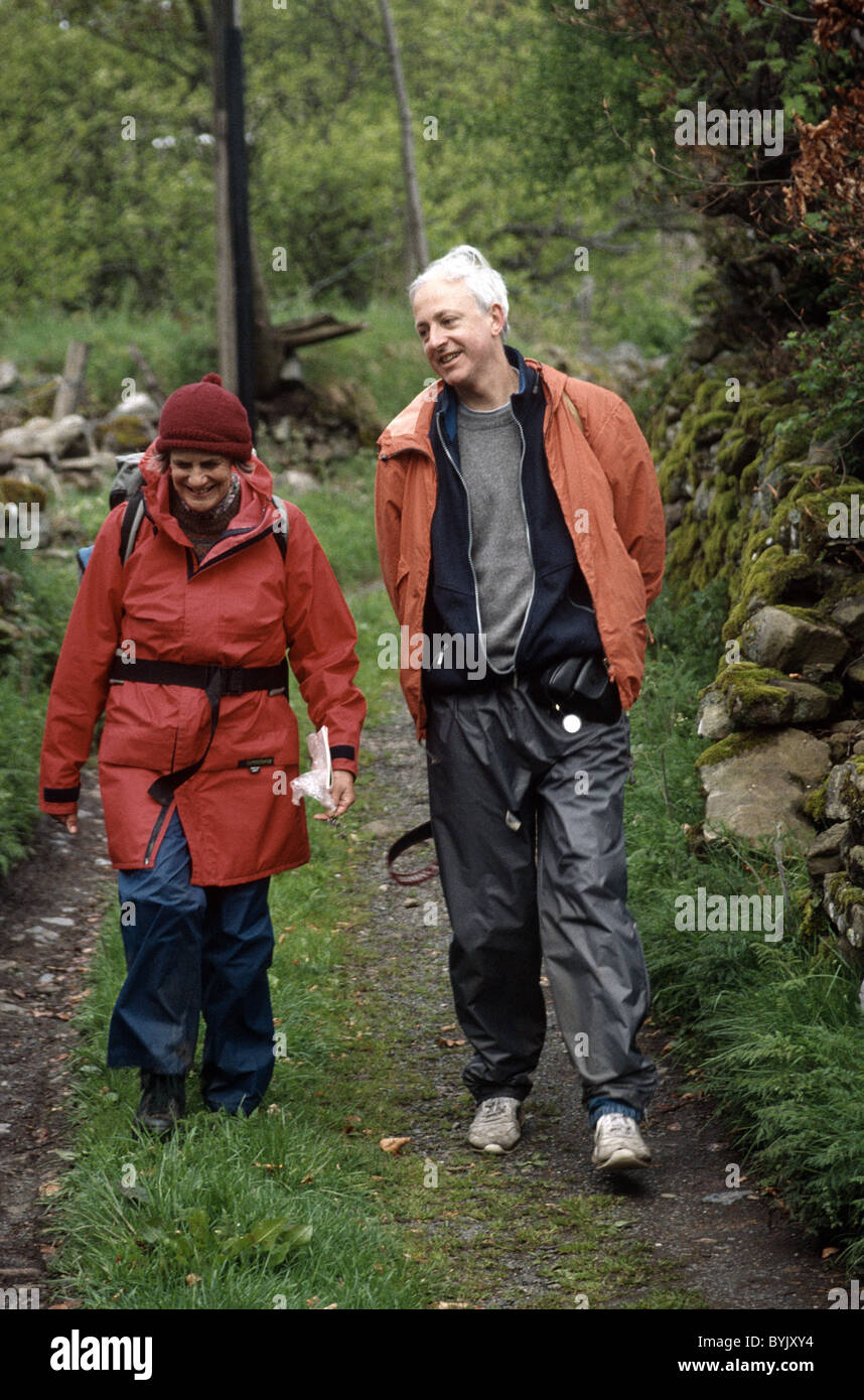 Due anziani escursionisti a piedi lungo un percorso di paese Foto Stock