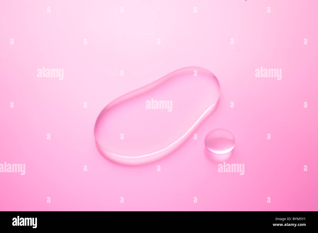 Goccia di acqua su sfondo rosa Foto Stock