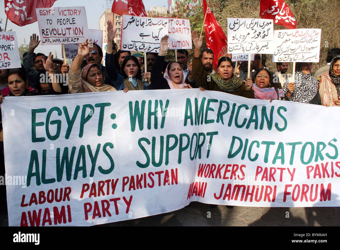 I sostenitori del partito laburista (LPP) cantano slogan in favore delle loro richieste durante la manifestazione di protesta presso il consolato americano a Lahore Foto Stock