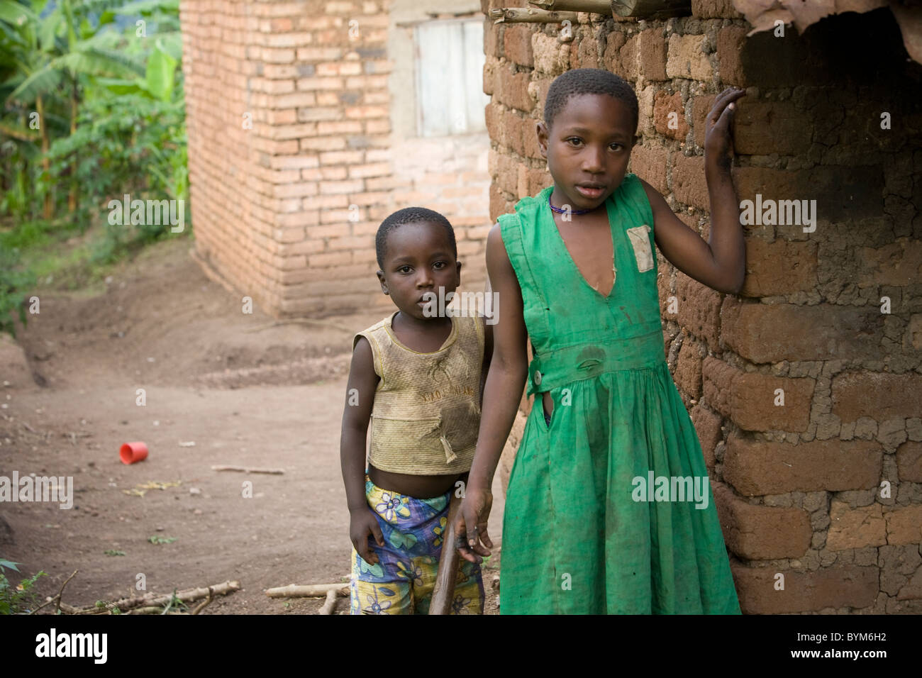 Due bambini stand al di fuori della loro casa in Masaka rurale, Uganda, Africa orientale. Foto Stock