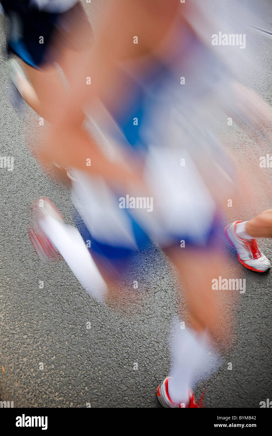 Uomo che corre in city marathon - sfocatura del movimento Foto Stock