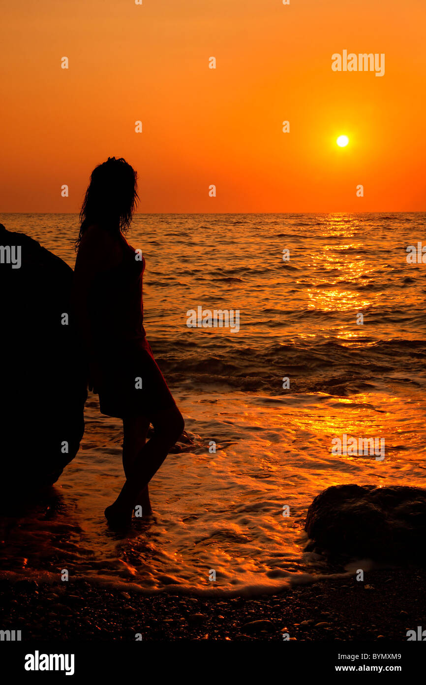 Un solitario lady godendo del tramonto, a Lycodemus beach, Cythera (o 'Kithira') Island, Grecia. Foto Stock