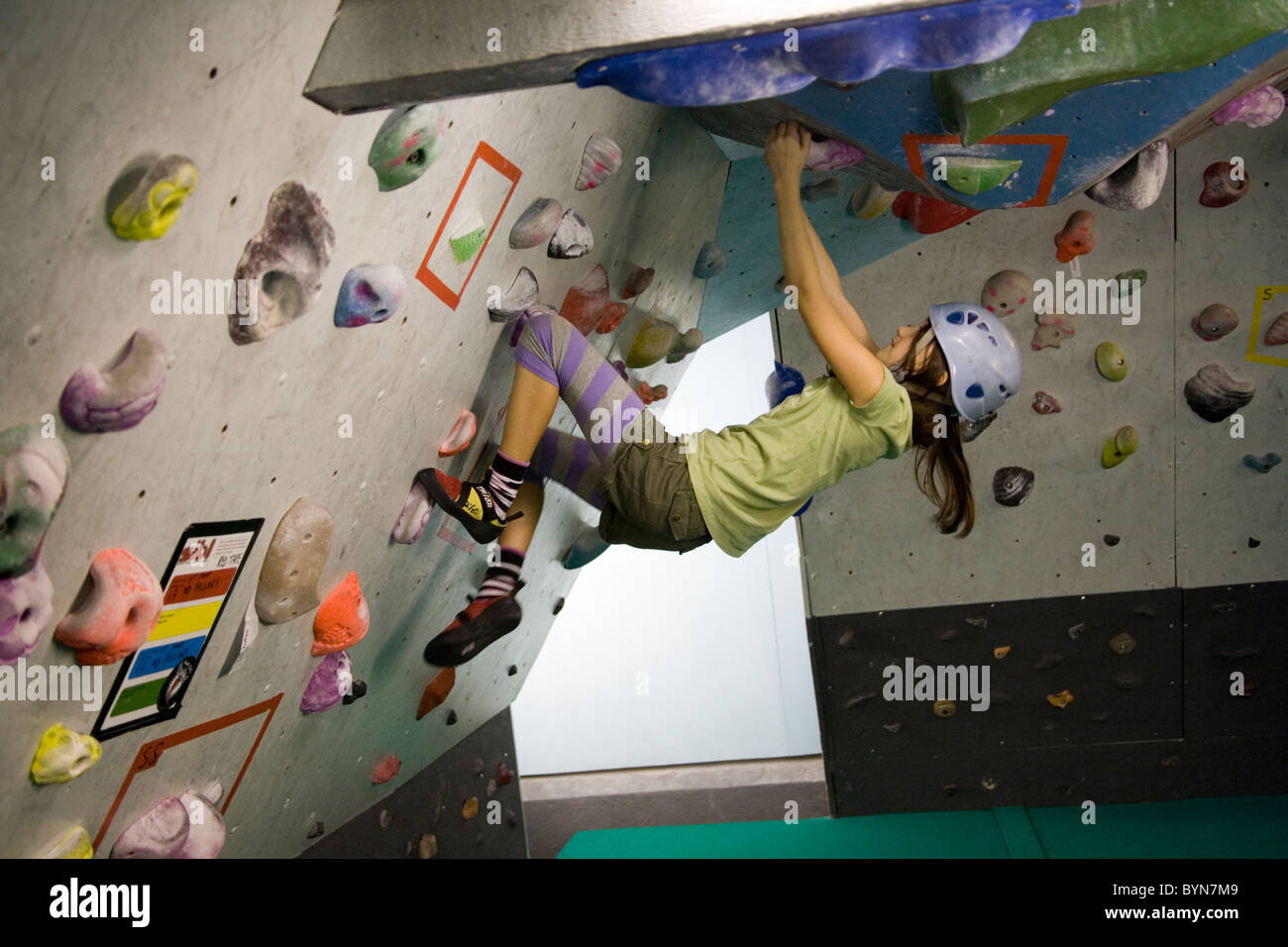 Parete di arrampicata; 12 anni ragazza sul muro di roccia da scalare, Mile End, East London Foto Stock