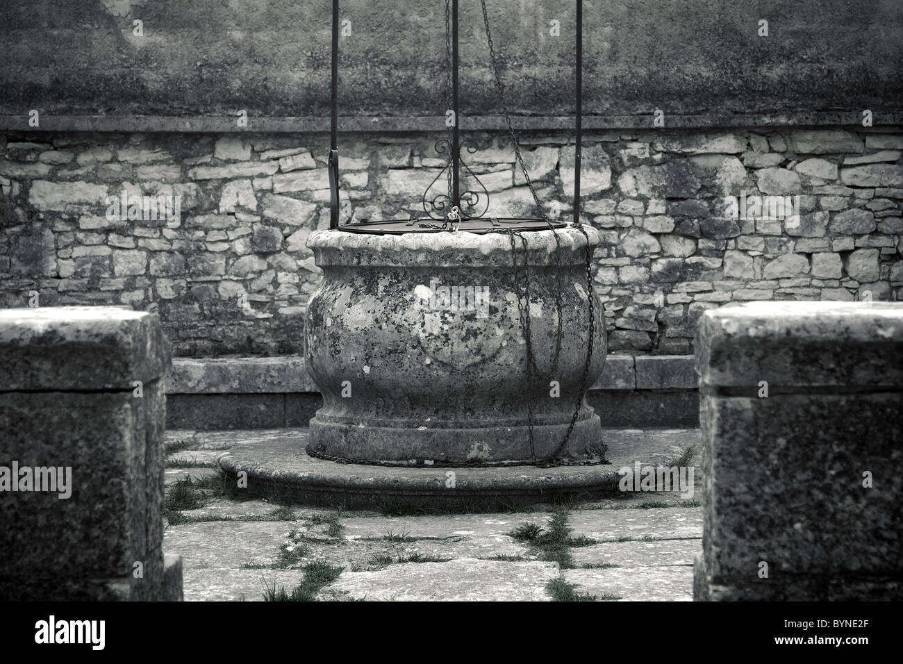 Il vecchio pozzo in pietra in un piccolo villaggio mediterraneo Foto Stock