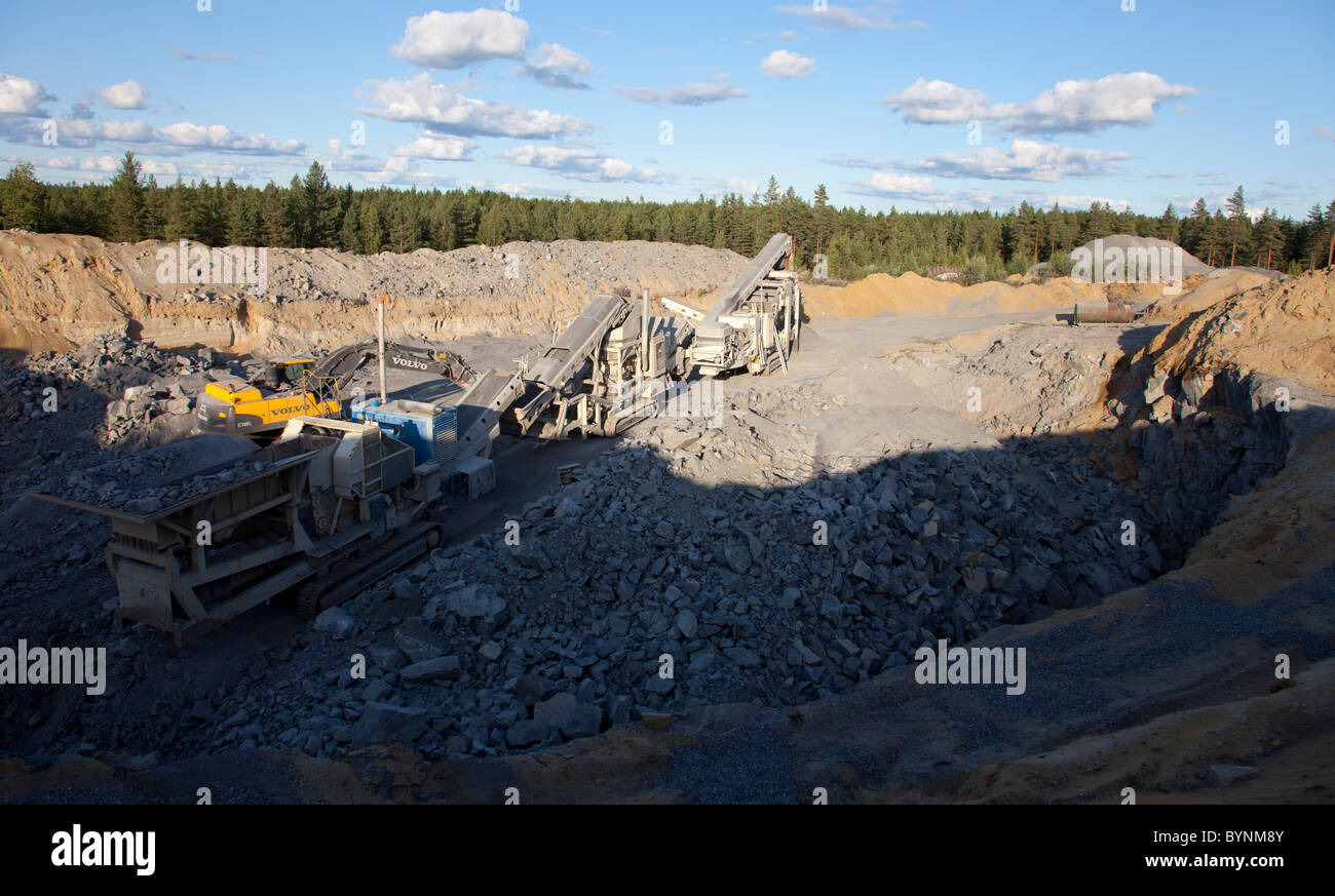 Le attrezzature di frantumazione delle rocce e sistema di trasporto a nastro al fondo di una piccola cava di roccia , Finlandia Foto Stock