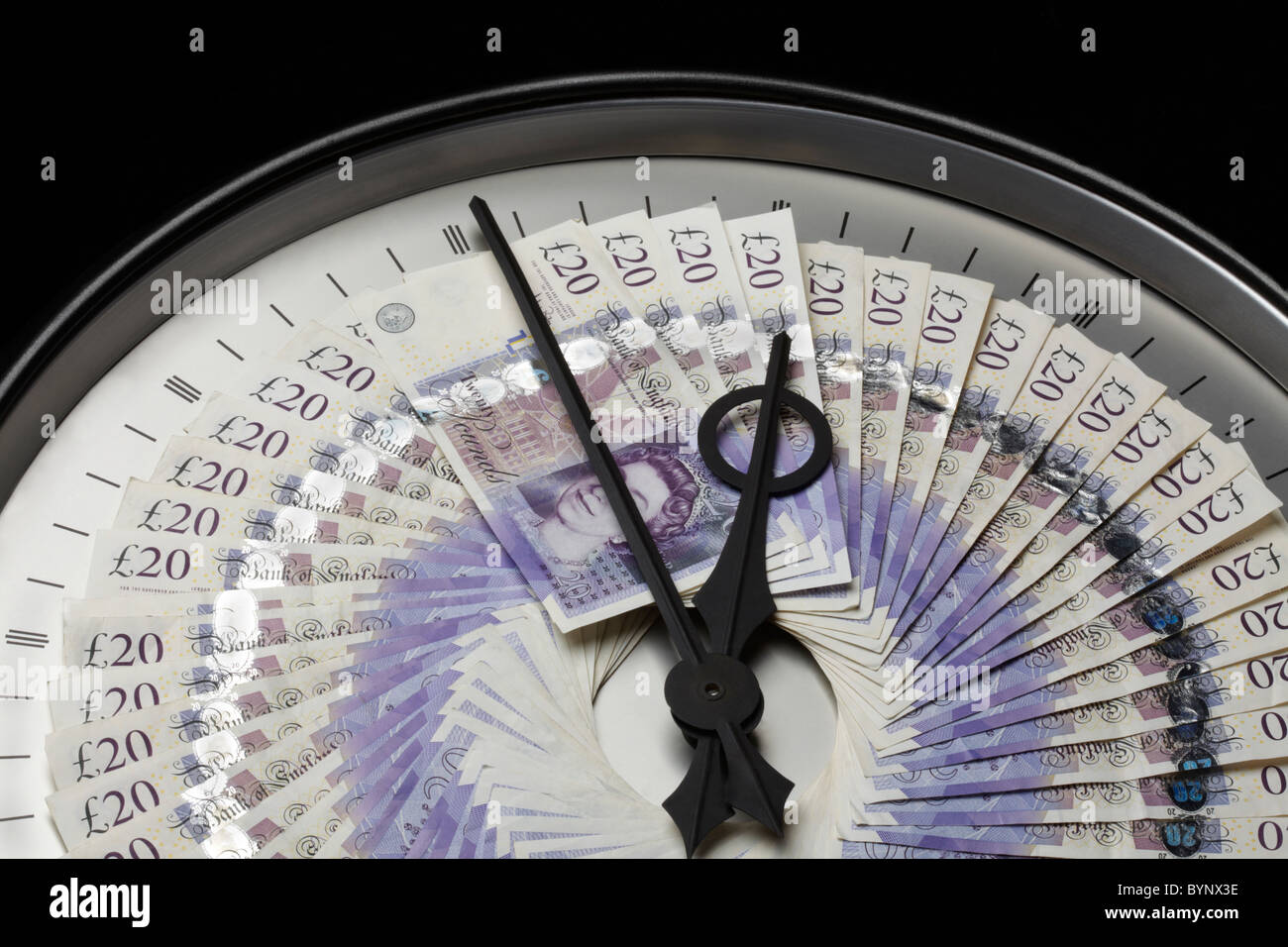 Venti Pound Note sull'orologio con le mani Foto Stock