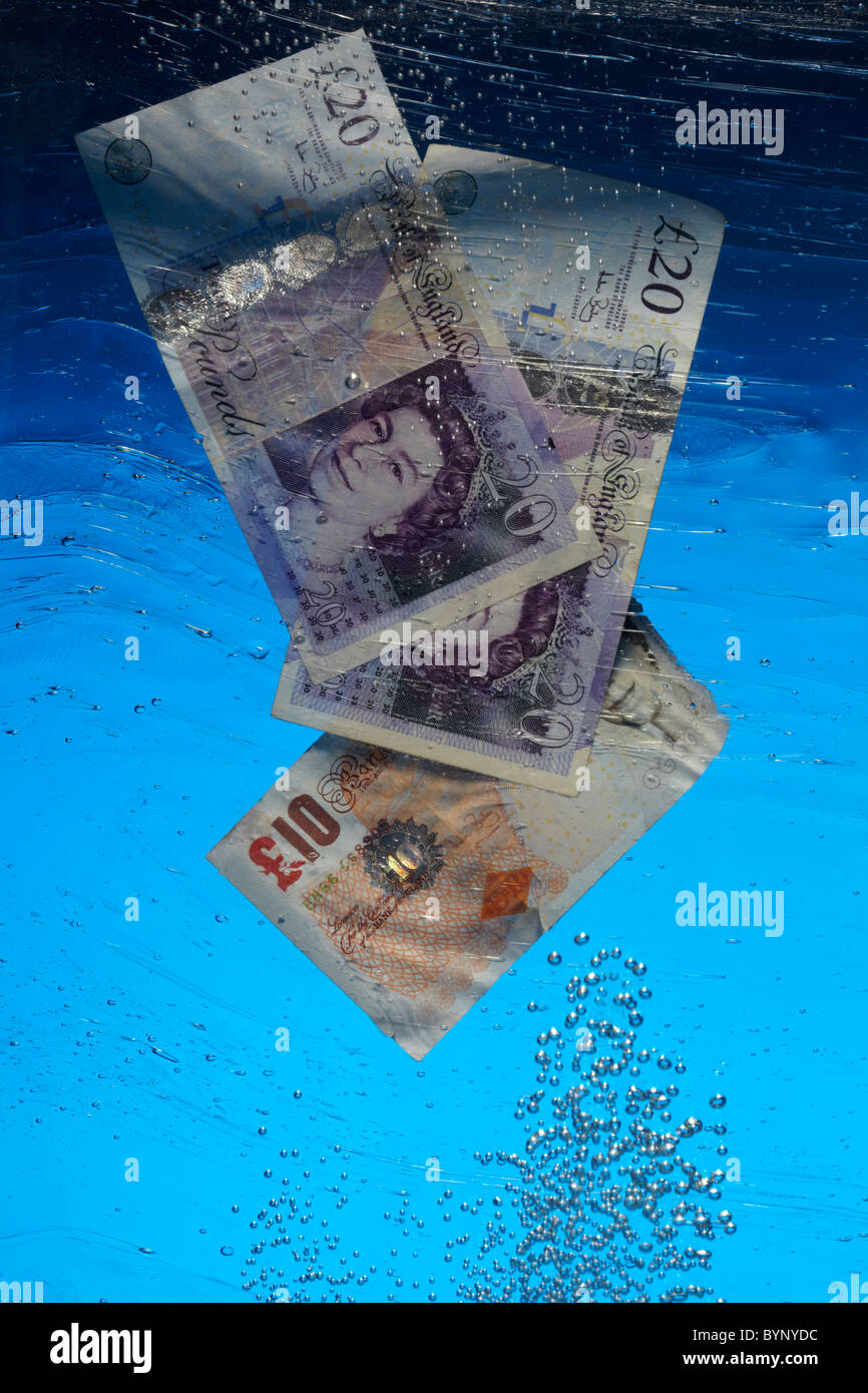 Pound Notes che affonda in acqua Foto Stock