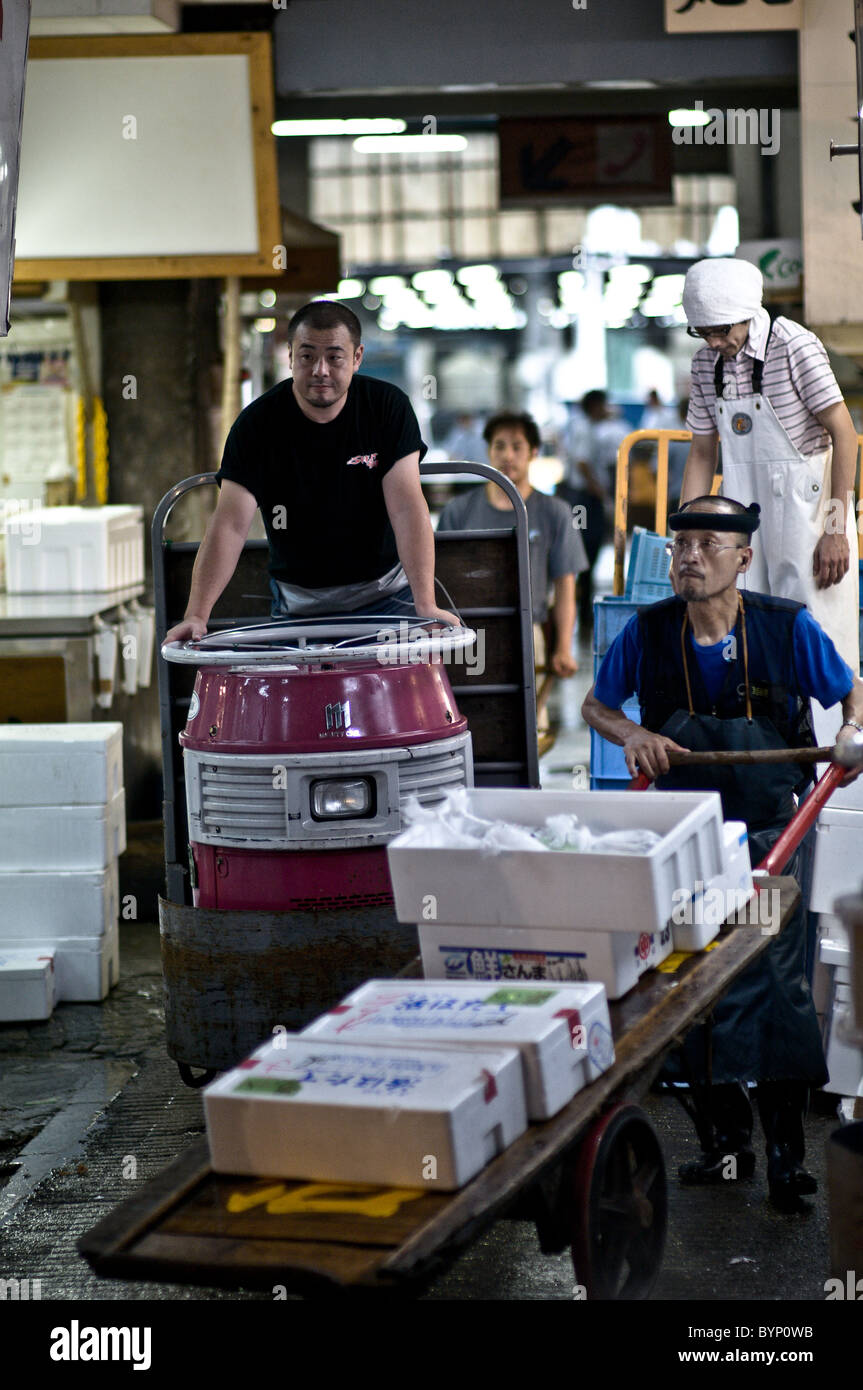 Lavoratori casi di trasporto di pesce per il mercato del pesce di Tsukiji Foto Stock