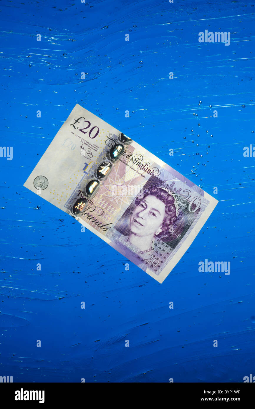 Venti Pound nota che affonda in acqua Foto Stock