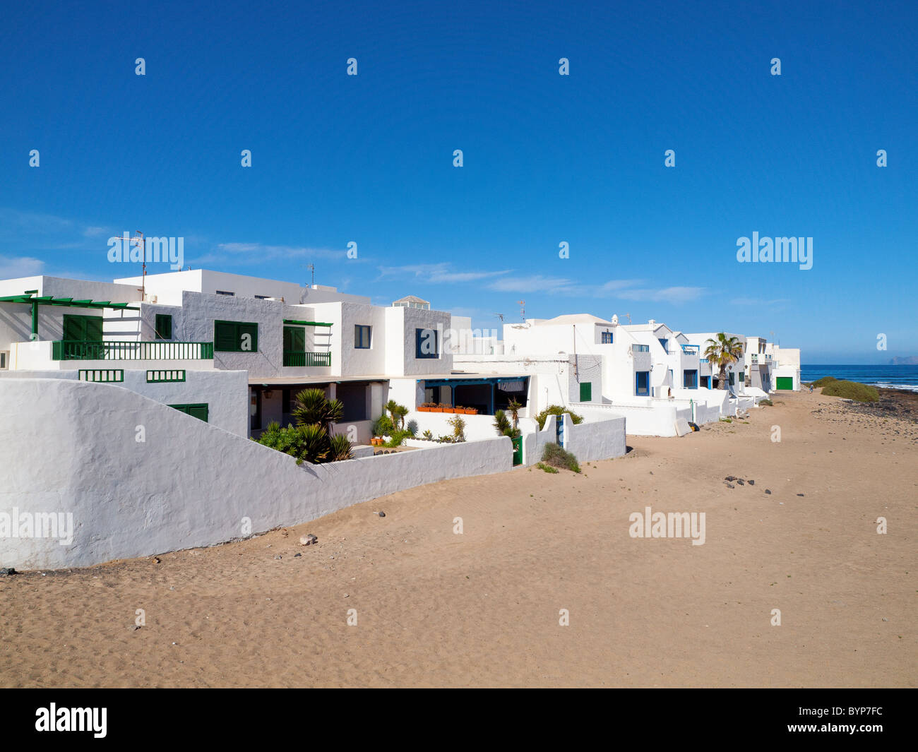 Ville per vacanze rivolta verso la Playa de Famara beach sulla non sviluppata sulla costa nord occidentale di Lanzarote isole Canarie Foto Stock