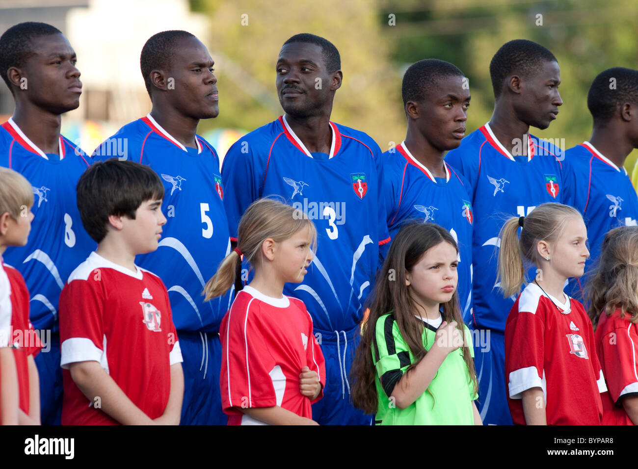 La Haitian National Soccer team e accompagnatori stand ad attenzione prima di una mostra con un team professionale di Austin in Texas Foto Stock