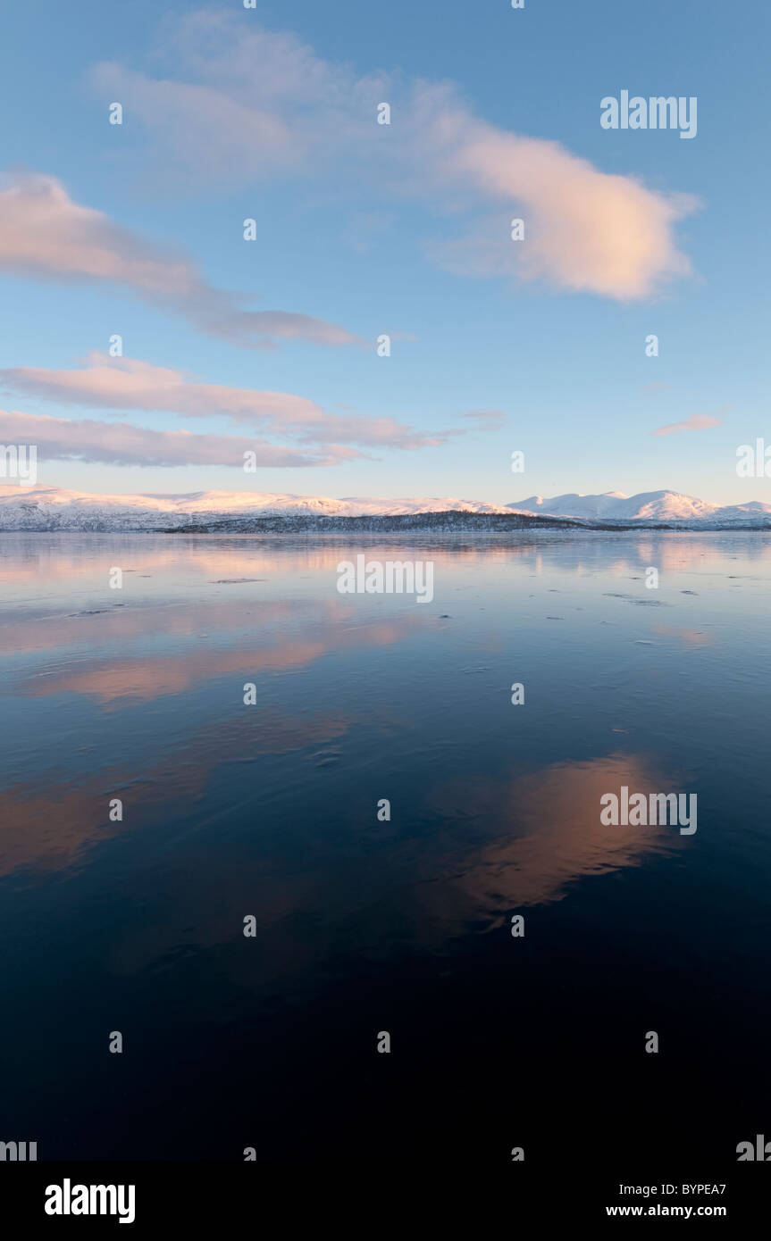 La riflessione sulle montagne nel lago ghiacciato Tornetraesk, Abisko, Lapponia, Svezia Foto Stock