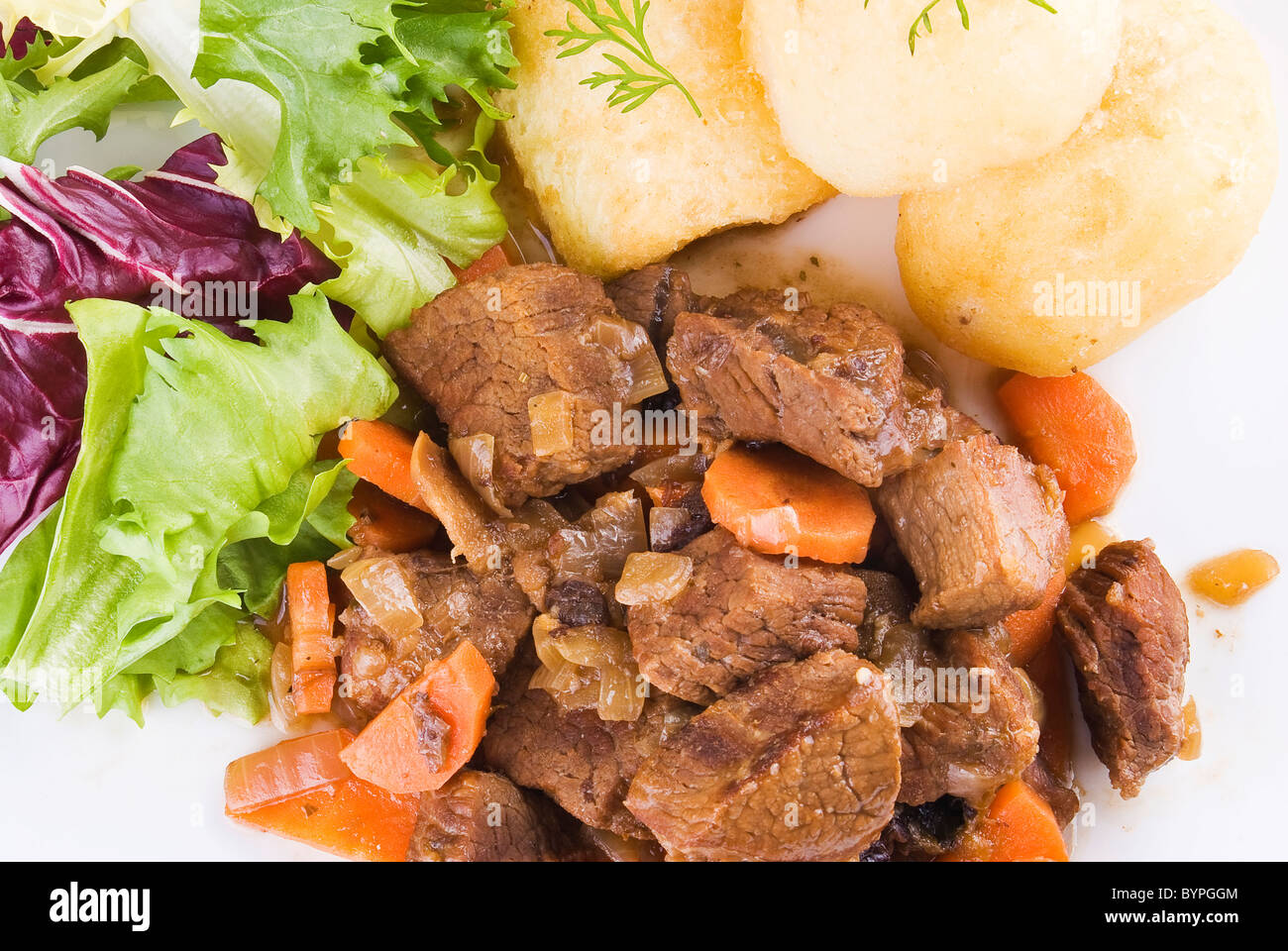 Pasto di stufati di carne di manzo con patate arrosto e insalata fresca Foto Stock