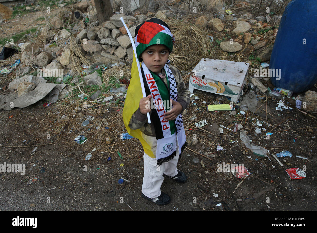 Un giovane ragazzo palestinese avvolto con la bandiera palestinese durante un raduno settimanale contro la costruzione della controversa le barriere di separazione essendo costruito da Israele in Cisgiordania villaggio di Bil'in Israele Foto Stock
