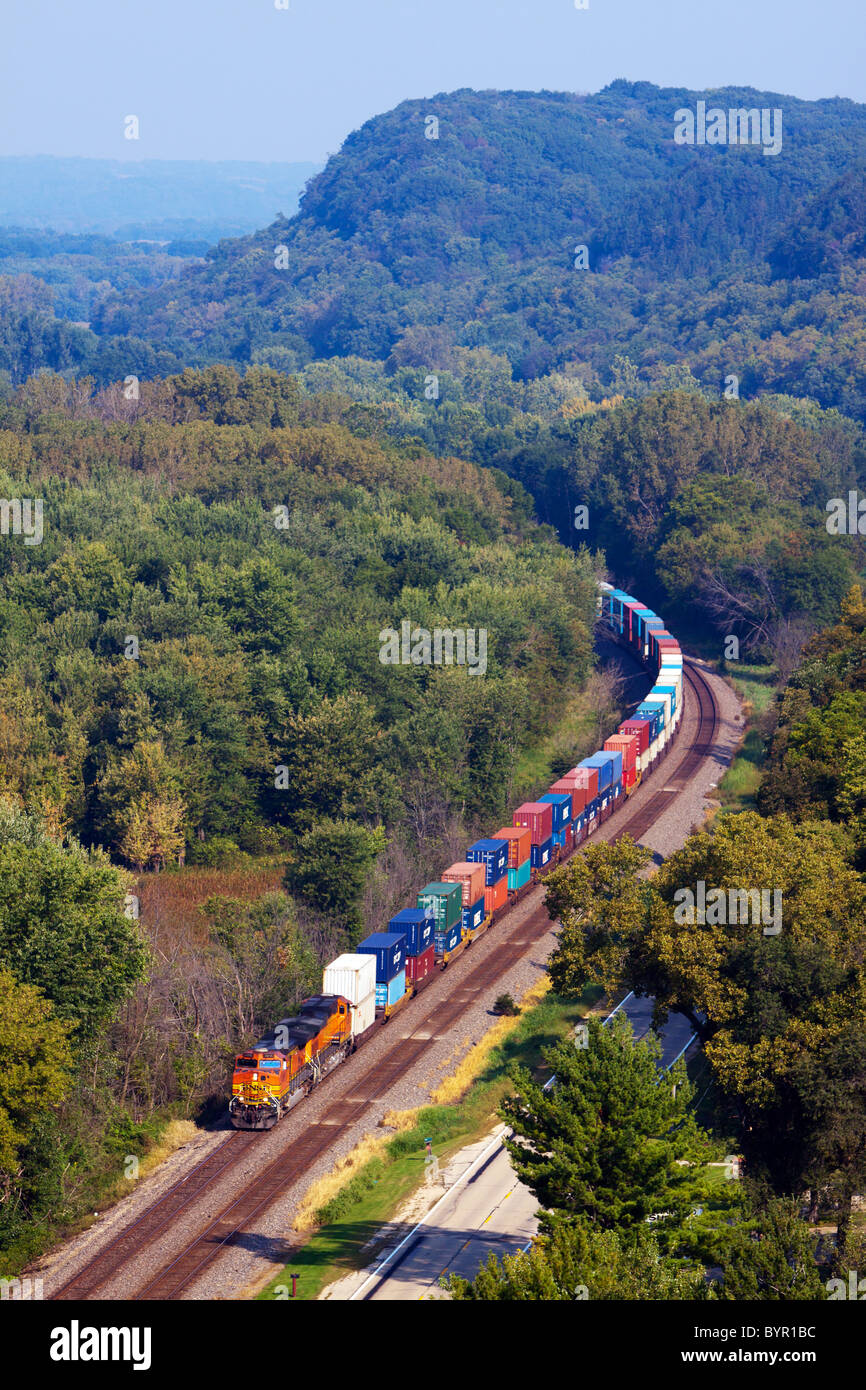 Una ferrovia BNSF treno intermodale rulli sotto le scogliere del Mississippi River Valley vicino a savana, IL. Foto Stock