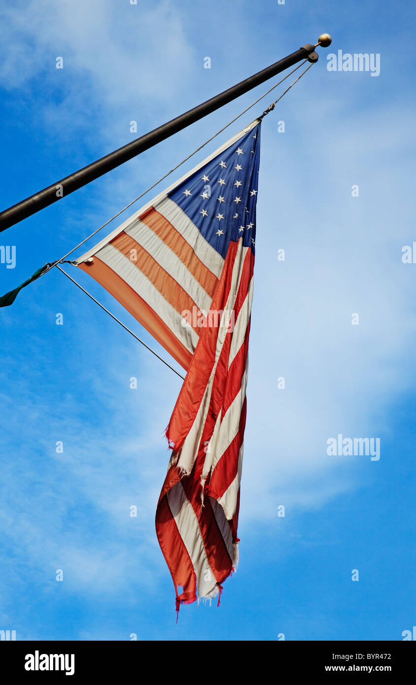 Vestito di stracci vecchi bandiera americana appesa sul palo. Foto Stock