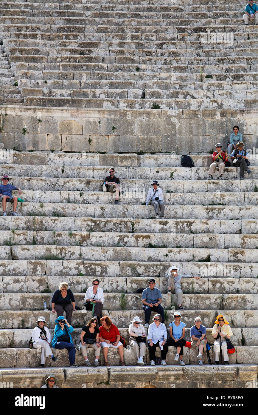 Gruppo di tour in seduta del Sud teatro di Gerasa, Jerash, Giordania Foto Stock