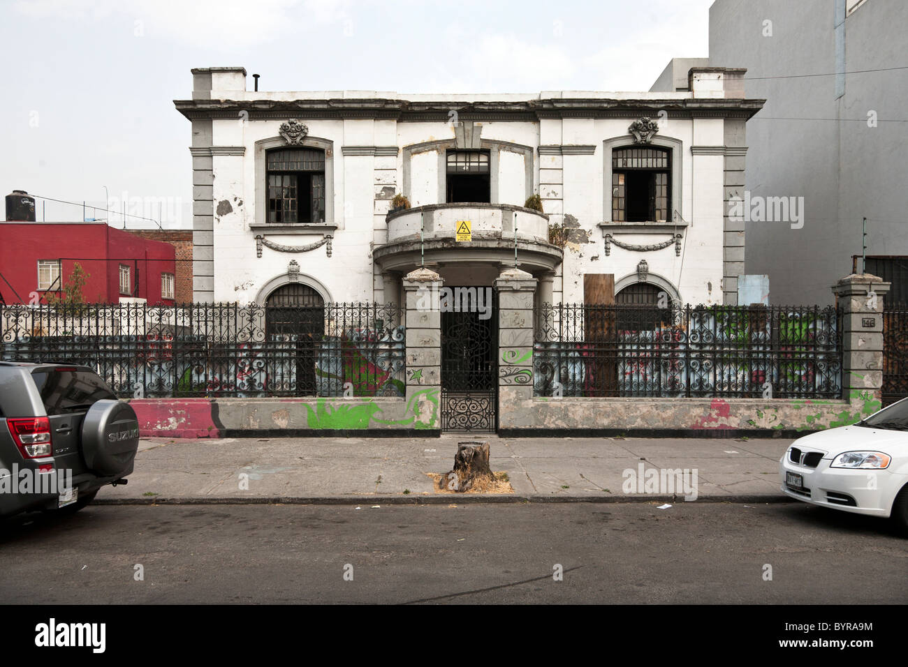 Una volta deteriorato orgoglioso Porfirian Belle Epoch mansion con elegante ferro battuto recinzione attorno a subire il restauro Città Del Messico Foto Stock