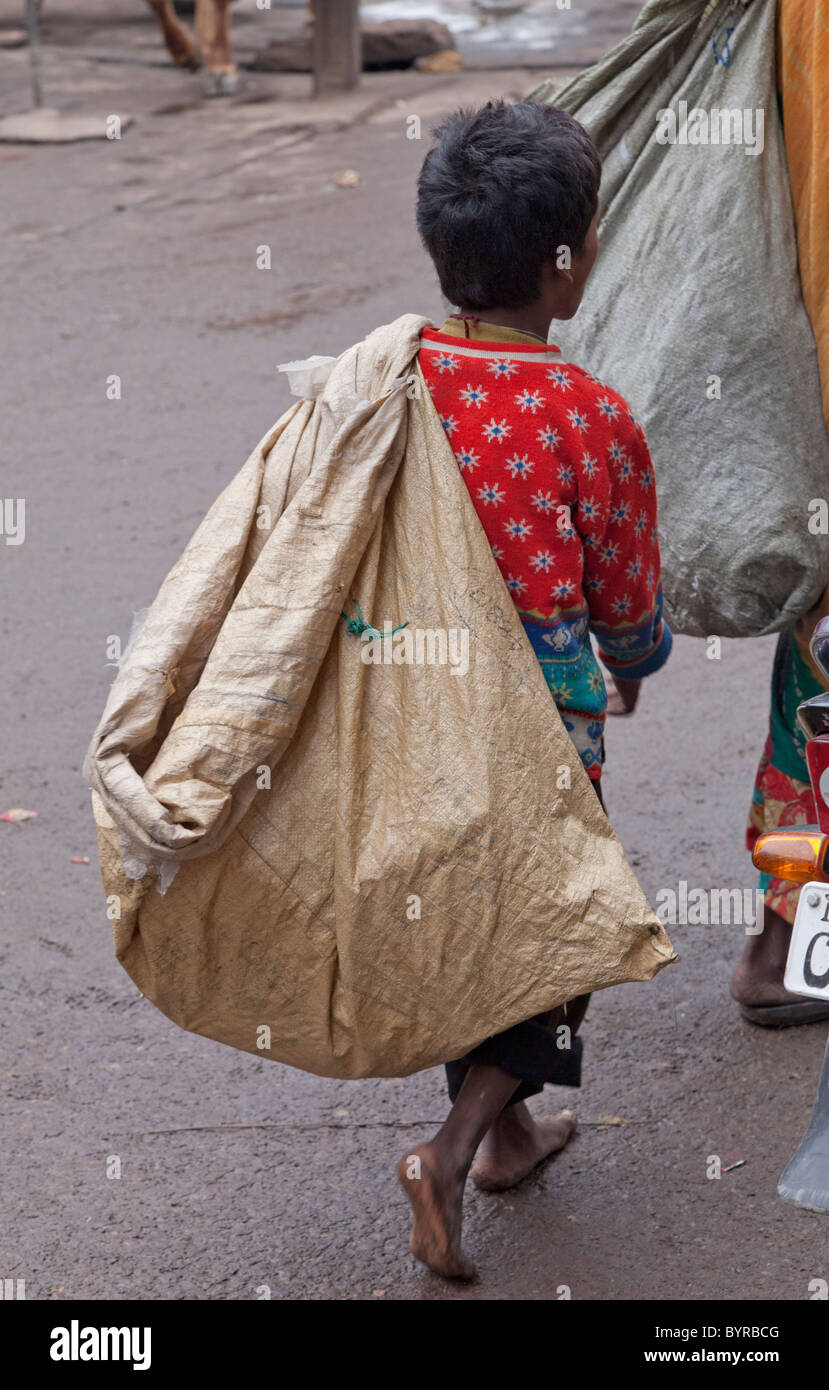 India Rajasthan, Jodhpur, bambino con sacchetto utilizzato per la raccolta di rifiuti riciclabili che poi vende per contanti Foto Stock