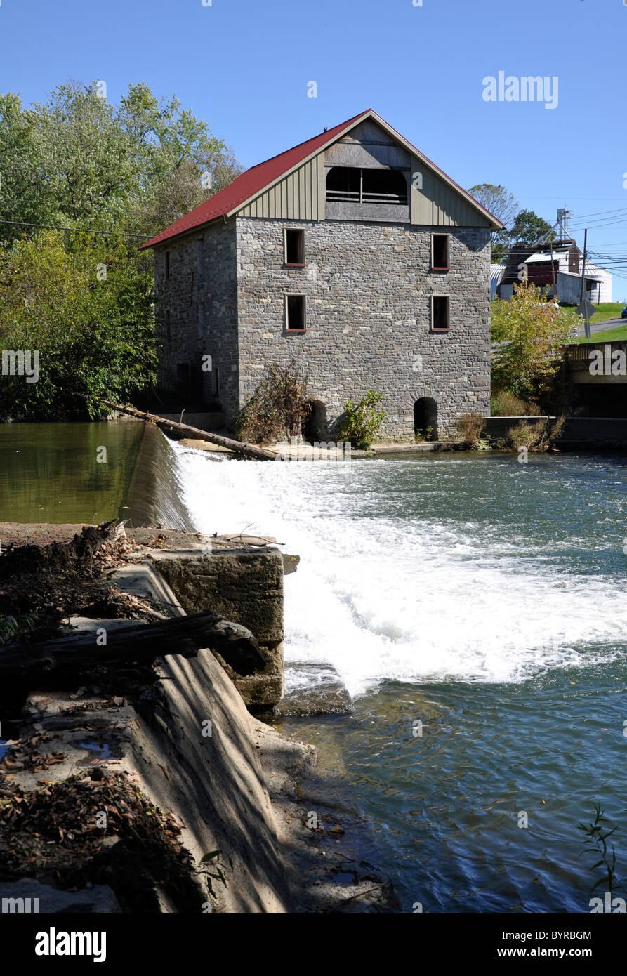 Antica pietra Grist Mill da una diga e cascata. Il Grist Mill si trova nella contea di Lehigh, Pennsylvania Foto Stock