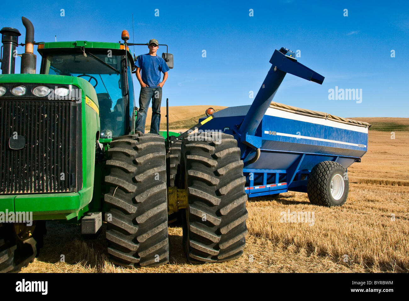 Un giovane agricoltore in cima il suo trattore durante una breve pausa da raccolto nella regione di Palouse / vicino al Pullman, Washington, Stati Uniti d'America. Foto Stock